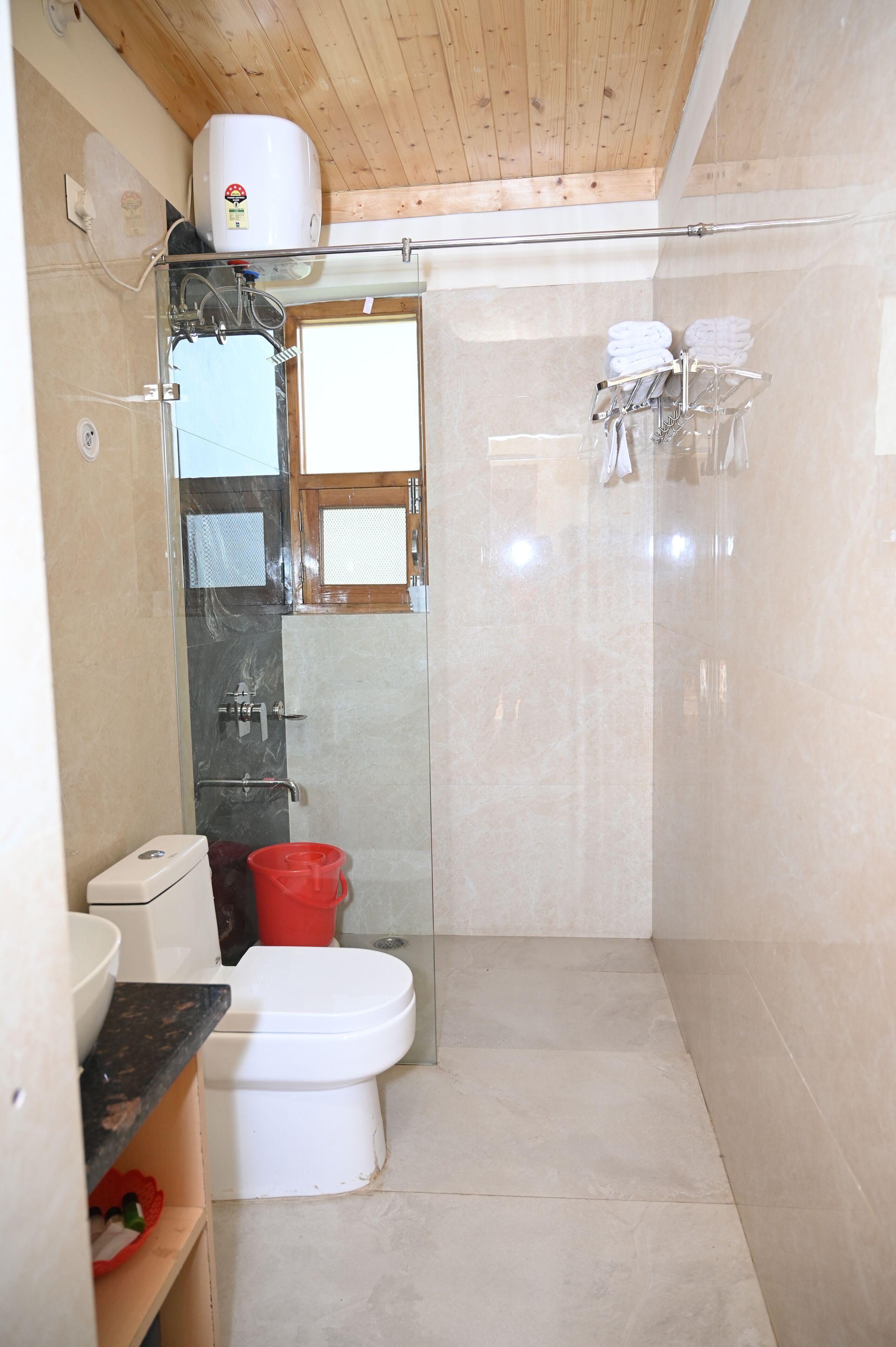 Un baño pequeño con inodoro, ducha y puerta de vidrio que da acceso a la zona de ducha.