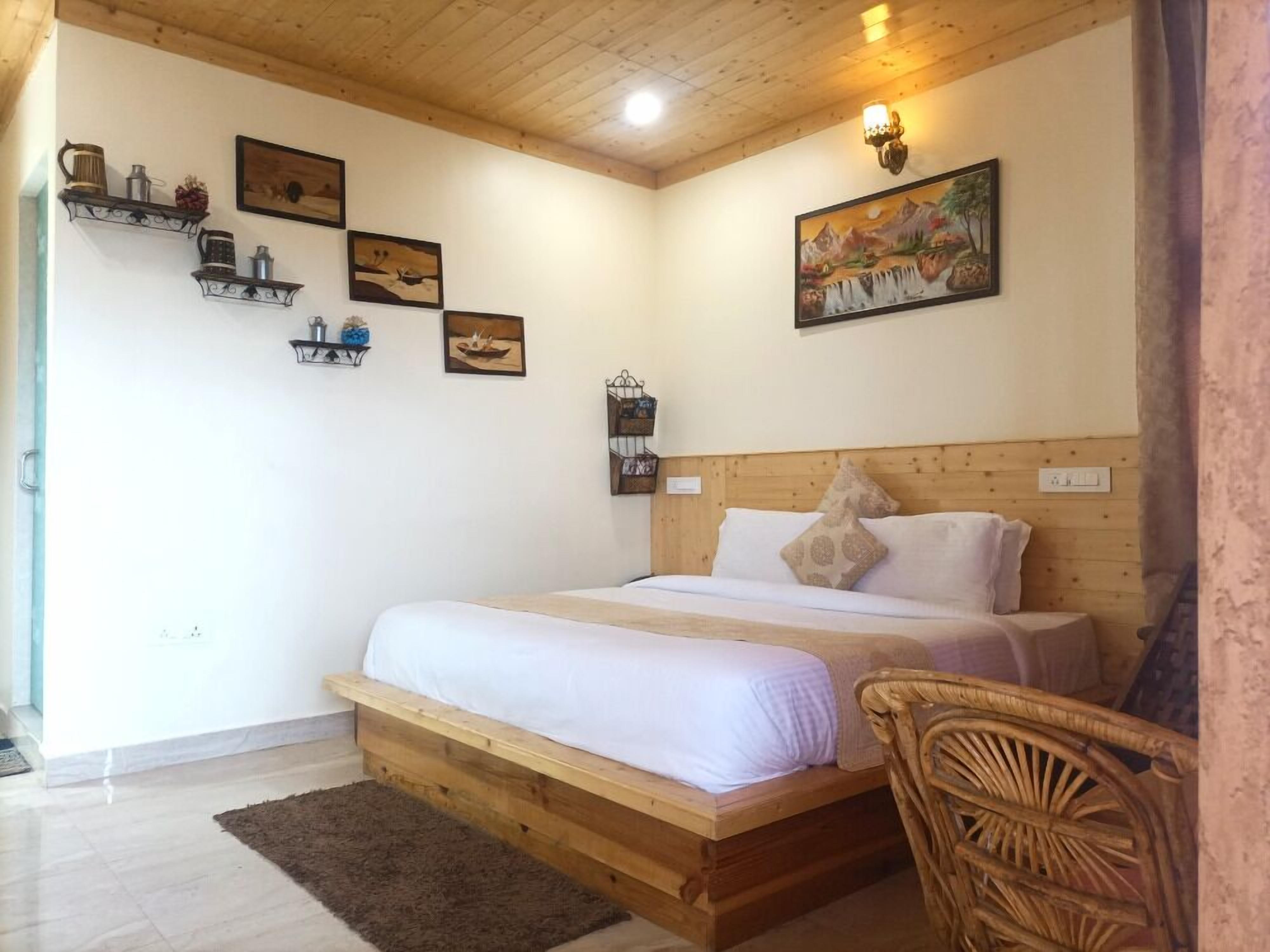 A bedroom with a wooden bed, white bedding, and a headboard. There are wall-mounted shelves with various items and a painting above the bed.