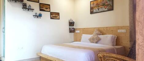 A bedroom with a wooden bed, white bedding, and a headboard. There are wall-mounted shelves with various items and a painting above the bed.