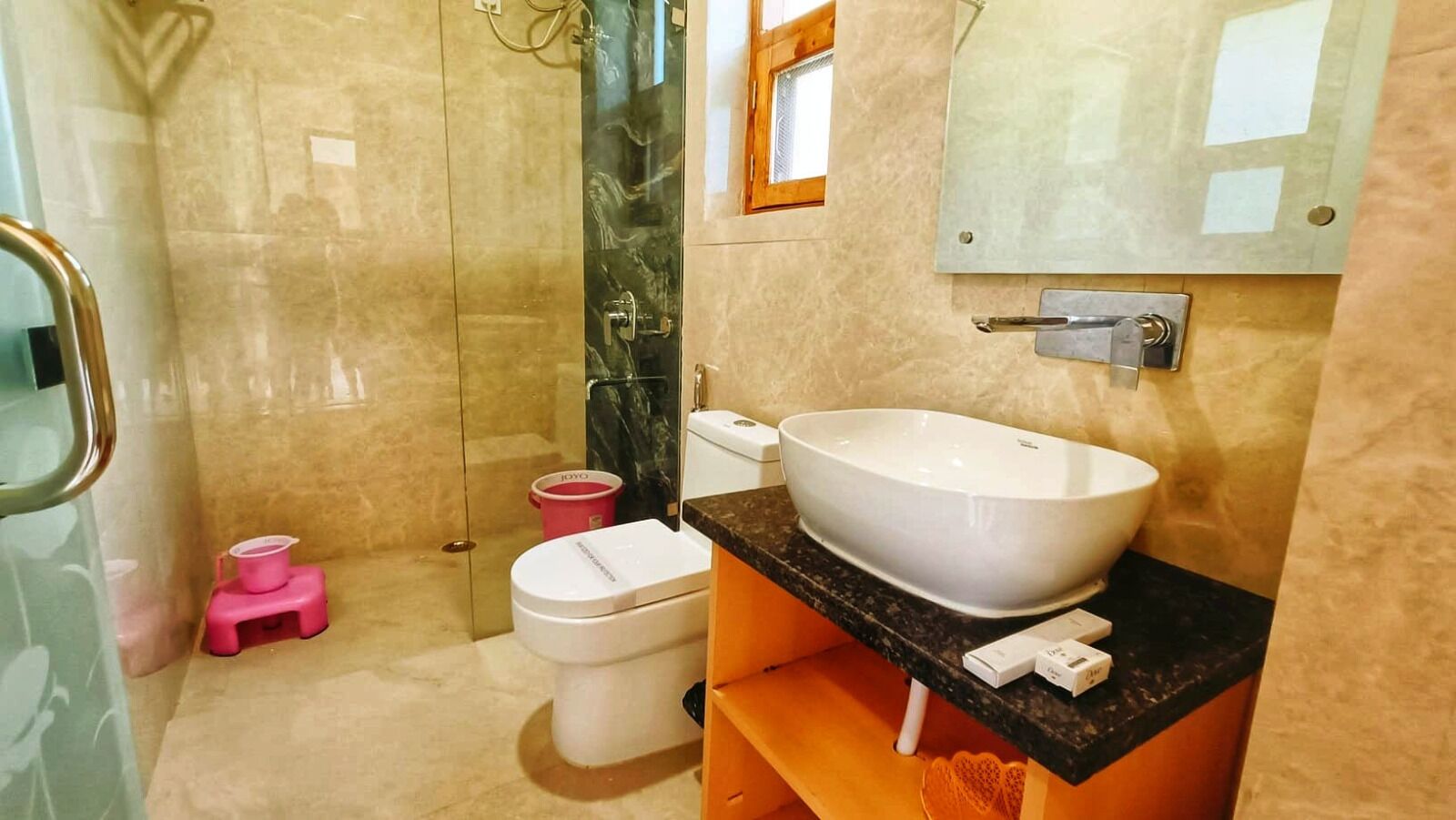 Un bagno con un lavabo bianco di grandi dimensioni, un water e una zona doccia.