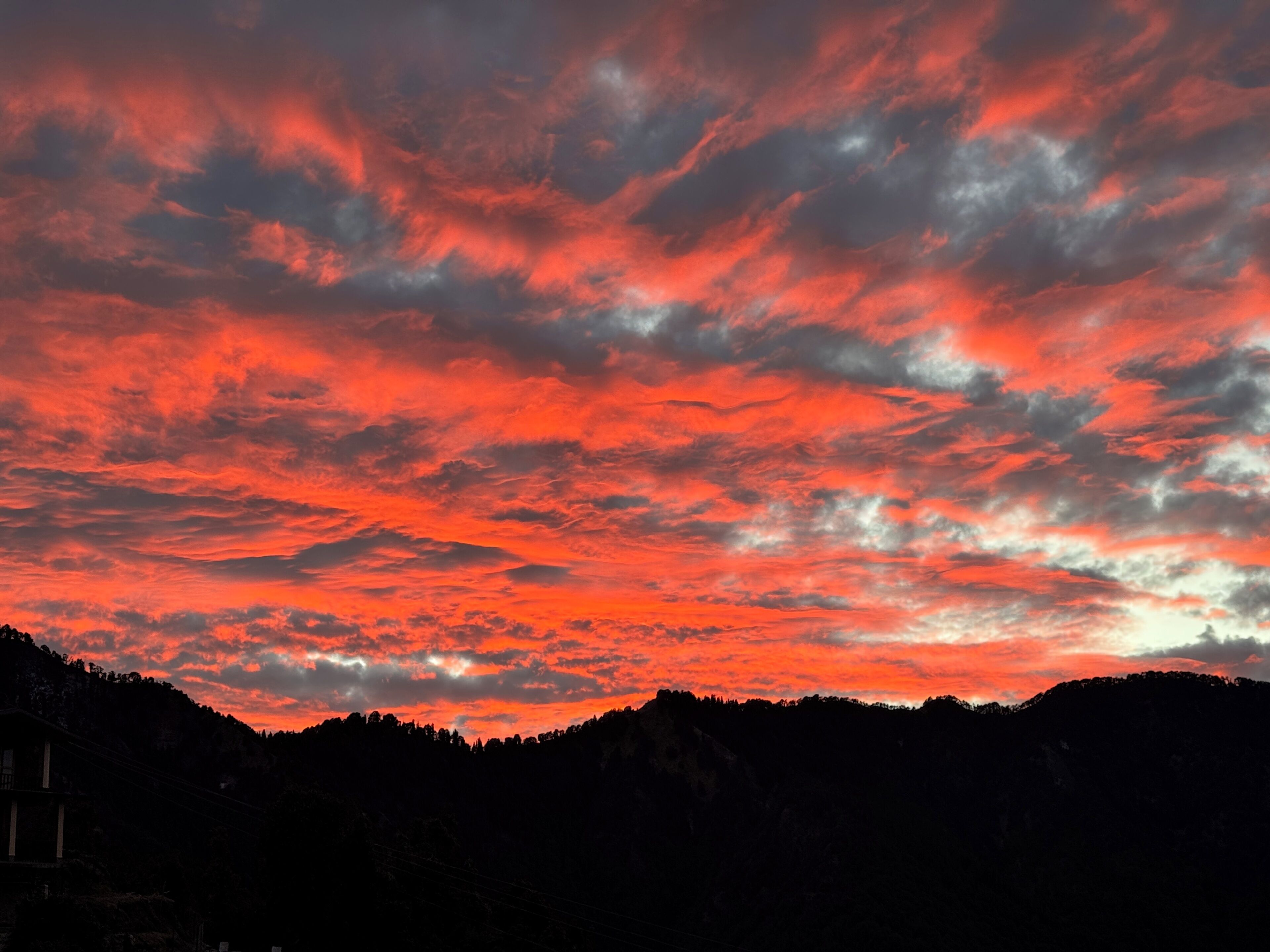 A sunset over a mountainous landscape with a red sky.