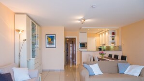 Un salon moderne comprenant un canapé, un meuble et un coin repas avec une table et des chaises.