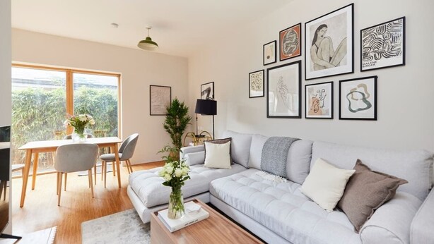 Ein modernes Wohnzimmer mit einer Couch, einem Couchtisch und Kunstwerken an der Wand.