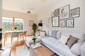 A modern living room with a sofa, coffee table, and artwork on the wall. - The Southwark Wonder - Charming 1bdr Flat With Patio (London)