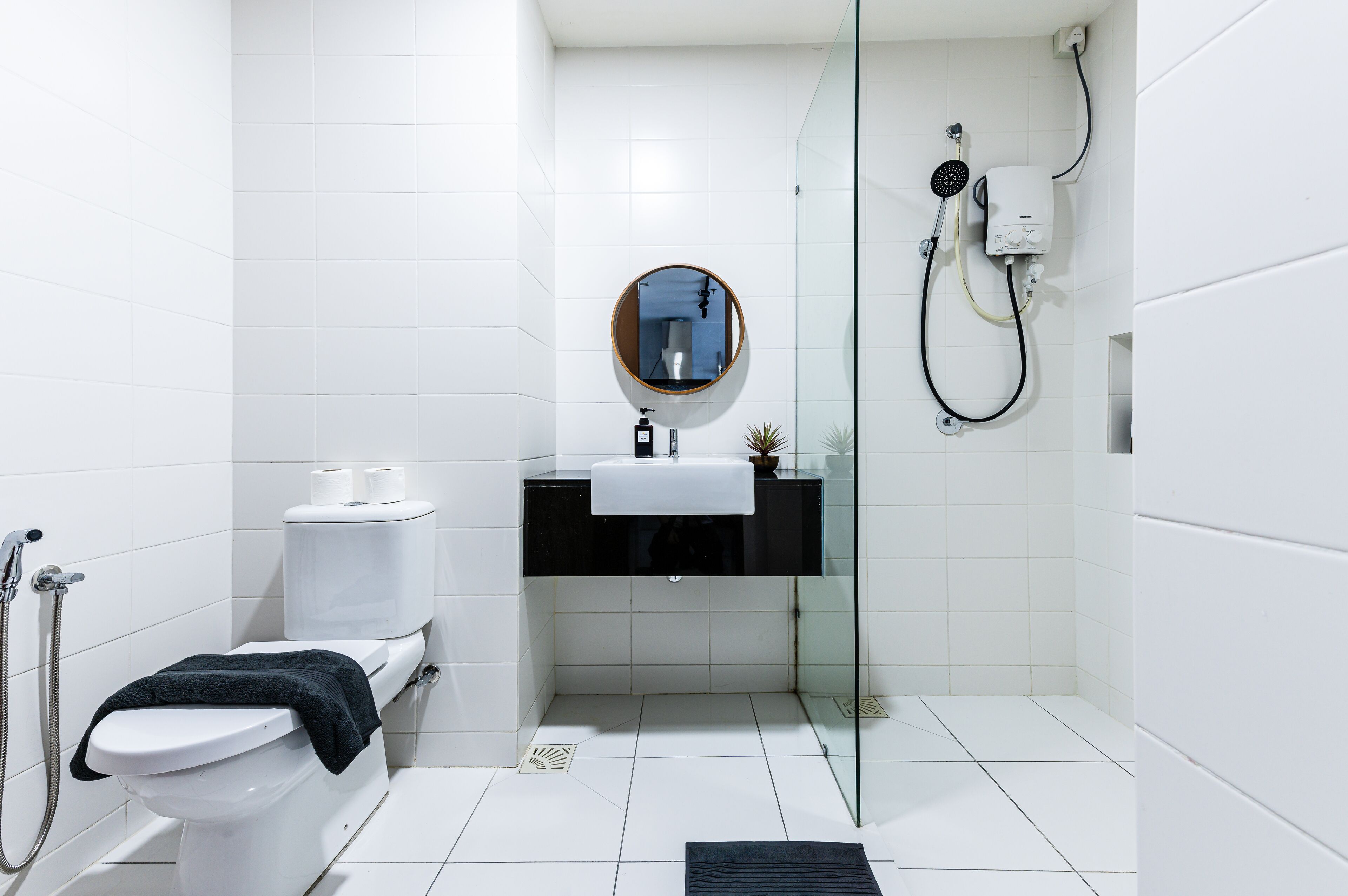 A modern bathroom with a toilet, sink, and shower.