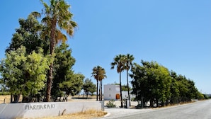 A road with a white building labeled "MARMARAKI" and palm trees. - MARMARAKI Village  (Kos)