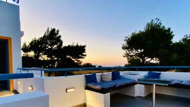 A rooftop terrace with a seating area, a table, and a railing. - MARMARAKI Village  (Kos)