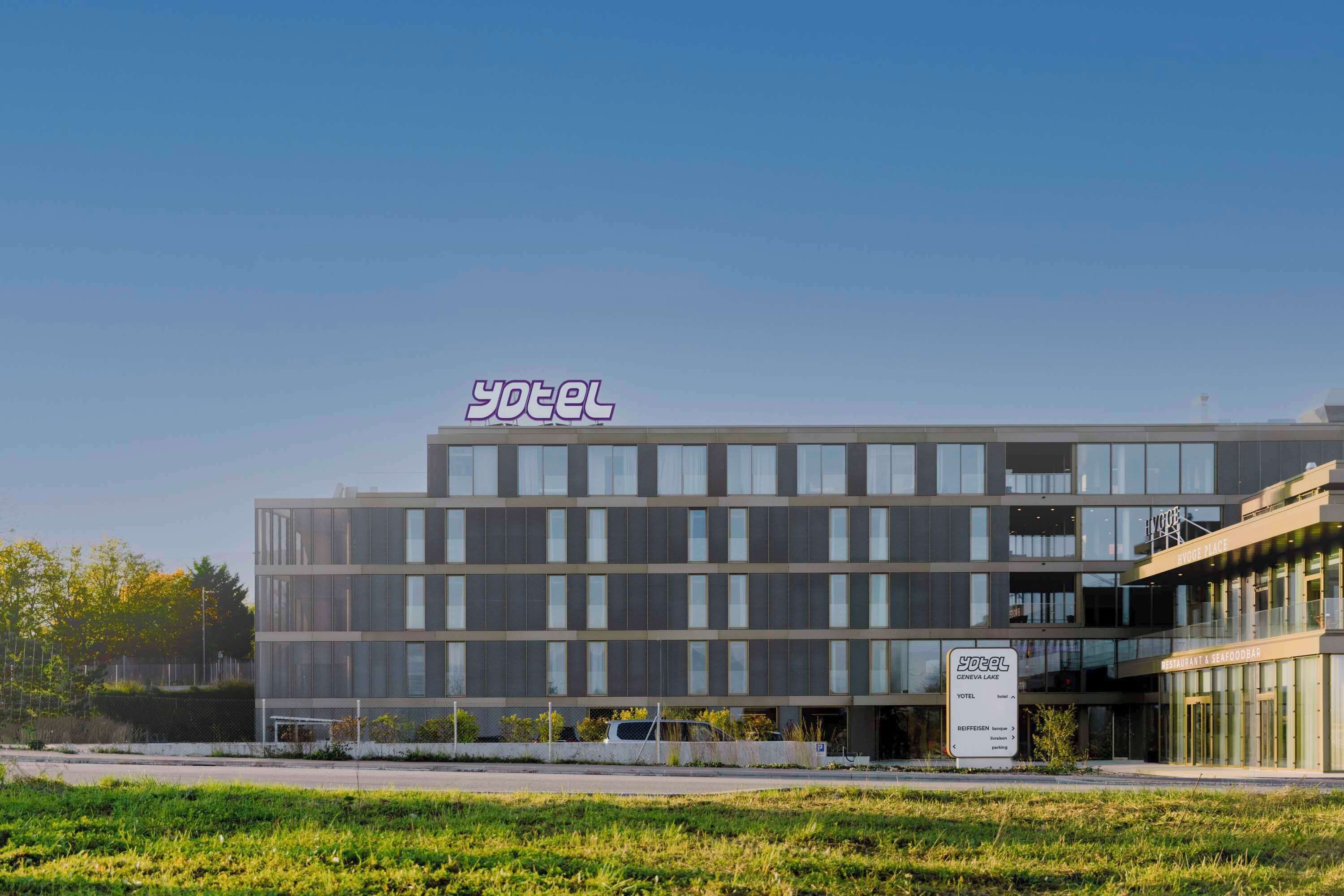 Ein modernes Hotelgebäude mit einem deutlichen Schild, auf dem "Yotel Geneva Lake" steht.