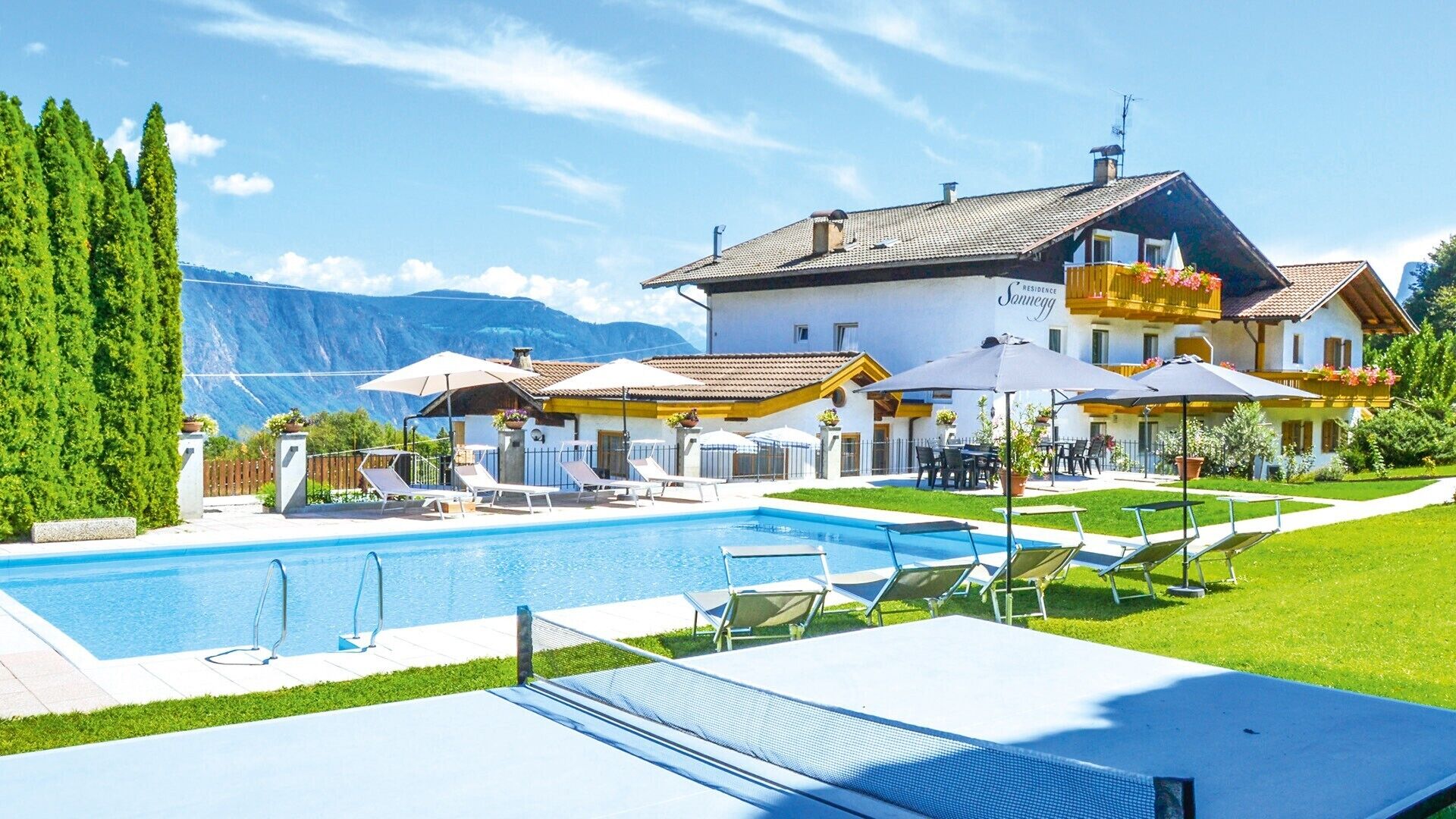 Ein Hotel mit Pool, Außenbereich und Blick auf die Berge.