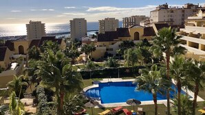 A resort with a swimming pool, palm trees, and buildings in the background. - Holiday Apartment 'Amazing In Puerto Alto' with Sea View, Shared Pool & Wi-Fi (Estepona)