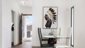 A modern room with a dining area, a bed, and a view of the outdoors. - Vacation Home "Gardenia" with Mountain View, Private Terrace & Wi-Fi (Costa Teguise)