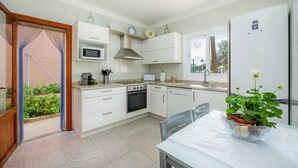 Une cuisine moderne avec des meubles blancs, un four à micro-ondes, une cuisinière et un lave-vaisselle.