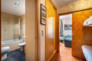 A bathroom with a shower, toilet, and bidet.