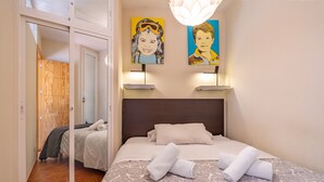 A bedroom with a bed, two paintings, a nightstand, and a sliding door leading to another room. - Apartment 'Diseño A Pie De Pista' with Mountain View and Wi-Fi (Monachil)