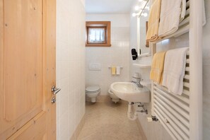 A bathroom with a toilet, sink, and towel rack. - Apartment 'Al Bait Da Marangona 3' with Mountain View, Shared Garden and Wi-Fi (Livigno)