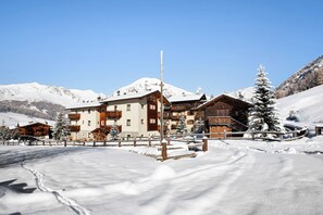 A snow-covered mountain resort with wooden buildings and a clear sky. - Apartment 'Al Bait Da Marangona 3' with Mountain View, Shared Garden and Wi-Fi (Livigno)