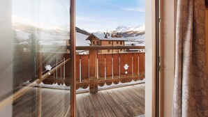 A wooden balcony with a view of snow-covered mountains. - Apartment 'Al Bait Da Marangona 5' with Mountain View, Shared Garden and Wi-Fi (Livigno)