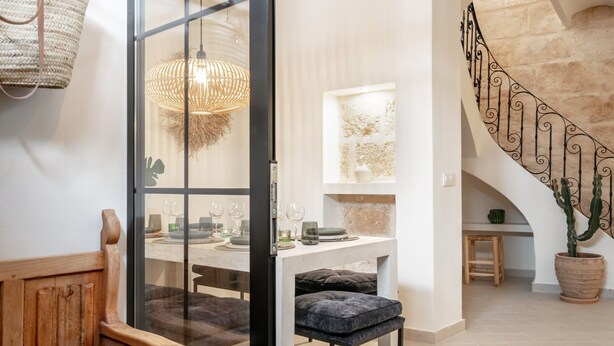 A modern interior with a dining area, a staircase, and a view of the outdoors. - Holiday Home 'Casa Roques 16' with Private Terrace, Wi-Fi and Air Conditioning (Xabia)