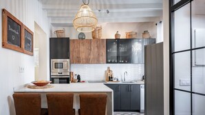A modern kitchen with a central island, wooden cabinets, a built-in oven, and a hanging light fixture. - Holiday Home 'Casa Roques 16' with Private Terrace, Wi-Fi and Air Conditioning (Xabia)