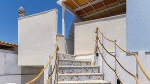A staircase with white railings and yellow ropes, leading to a building with a tiled wall. - Apartment 'Corallo In Oasi Del Mare' with Sea View and Wi-Fi (Granelli)