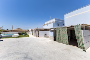 A residential property with a swimming pool, a covered patio, and a garage.