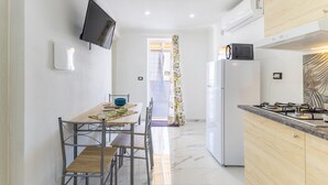 A compact kitchen with a TV, a refrigerator, and a microwave. - Apartment 'Corallo In Oasi Del Mare' with Sea View and Wi-Fi (Granelli)