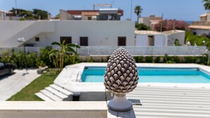 A pool with a decorative finial, a white building in the background, and a clear sky. - Apartment 'Corallo In Oasi Del Mare' with Sea View and Wi-Fi (Granelli)
