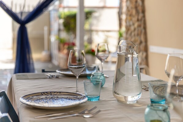 A table set for dining with a pitcher, glasses, and a plate. - Holiday Home 'Loft Le Palme' with Private Terrace, Wi-Fi and Air Conditioning (Portopalo di Capo Passero)