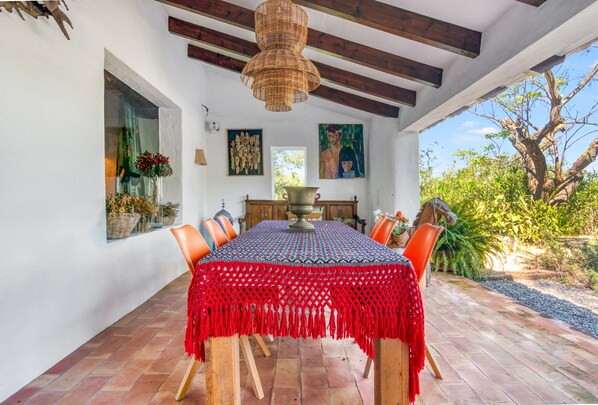 A dining area with a table, chairs, a decorative centerpiece, and a view of the outdoors.
