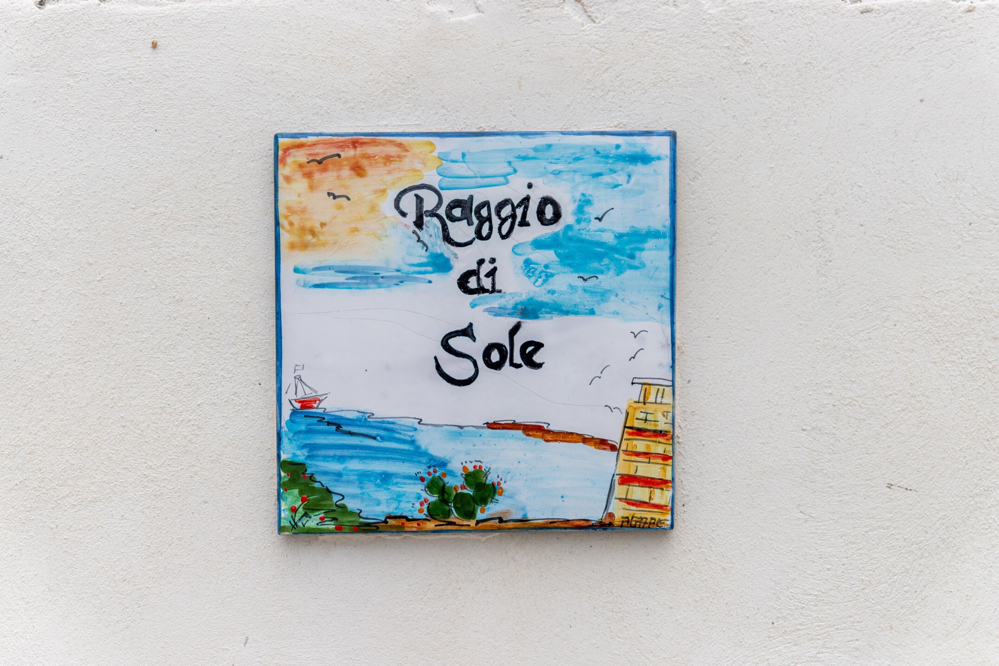 Une œuvre d’art colorée avec le texte « Ragazzo di Sole » et une scène de bord de mer.