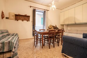 Quarto com mesa de jantar, cadeiras, cama, guarda-roupa e um candelabro.