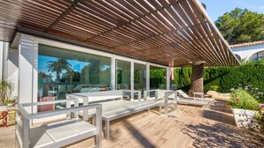 A modern outdoor seating area with benches and a pergola. - Villa 'Traviata ' with Sea View, Private Pool, Wi-Fi and Air Conditioning (Benissa(Alicante))