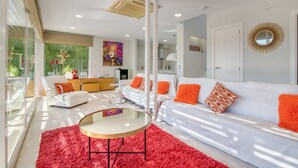 A modern living room with a white sofa, red rug, and a glass partition. - Villa 'Traviata ' with Sea View, Private Pool, Wi-Fi and Air Conditioning (Benissa(Alicante))