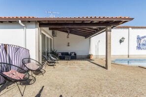 A covered outdoor area with a pool, seating, and a tiled wall. - Casa do Terreiro with private pool, private terrace, and Wi-Fi (Barqueiros)