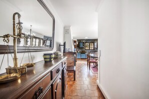 A hallway with a wooden cabinet, a mirror, and a chandelier. - Casa do Terreiro with private pool, private terrace, and Wi-Fi (Barqueiros)