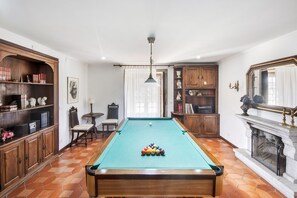 A billiards room with a pool table, wooden cabinets, and a fireplace. - Casa do Terreiro with private pool, private terrace, and Wi-Fi (Barqueiros)