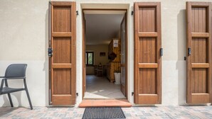 A doorway with wooden doors, a black chair, and a tiled floor.