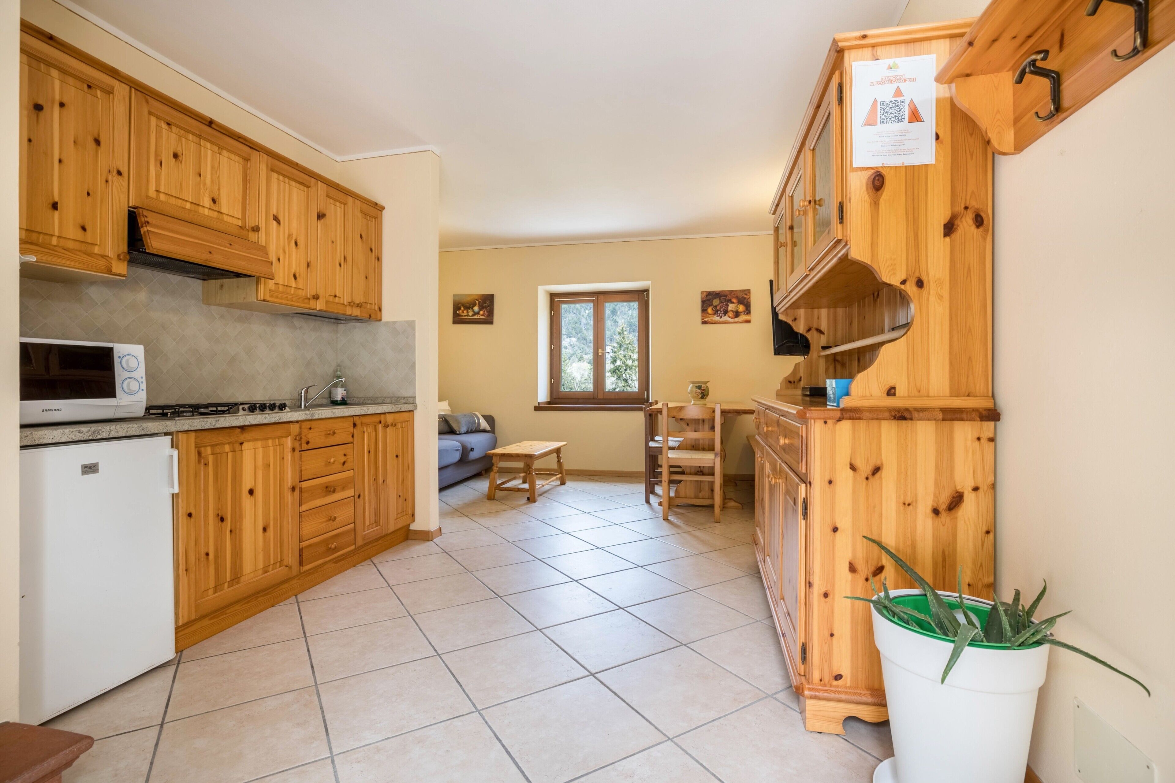 A compact kitchen with wooden cabinets, a microwave, and a sink.