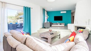 Een moderne woonkamer met een bank, salontafel en een flatscreen televisie.