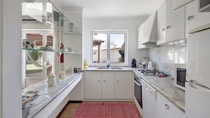 A modern kitchen with white cabinets, a marble countertop, a gas stove, and a dishwasher. - Holiday Home 'Moinho De Paradela' with Private Pool, Private Terrace and Wi-Fi (Paradela)