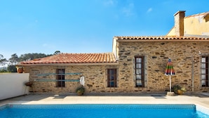 A stone building with a tiled roof, a swimming pool with blue tiles, and a colorful umbrella. - Holiday Home 'Azenha Da Lagoa Negra' with Lake View, Private Pool and Wi-Fi (Barqueiros)