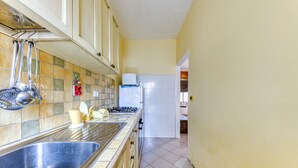 A kitchen with a stainless steel sink, a stove, and cabinets. - Holiday Apartment "Baia Del Mare" with 2 Private Terraces, Private Garden & A/C (Lido Marini)