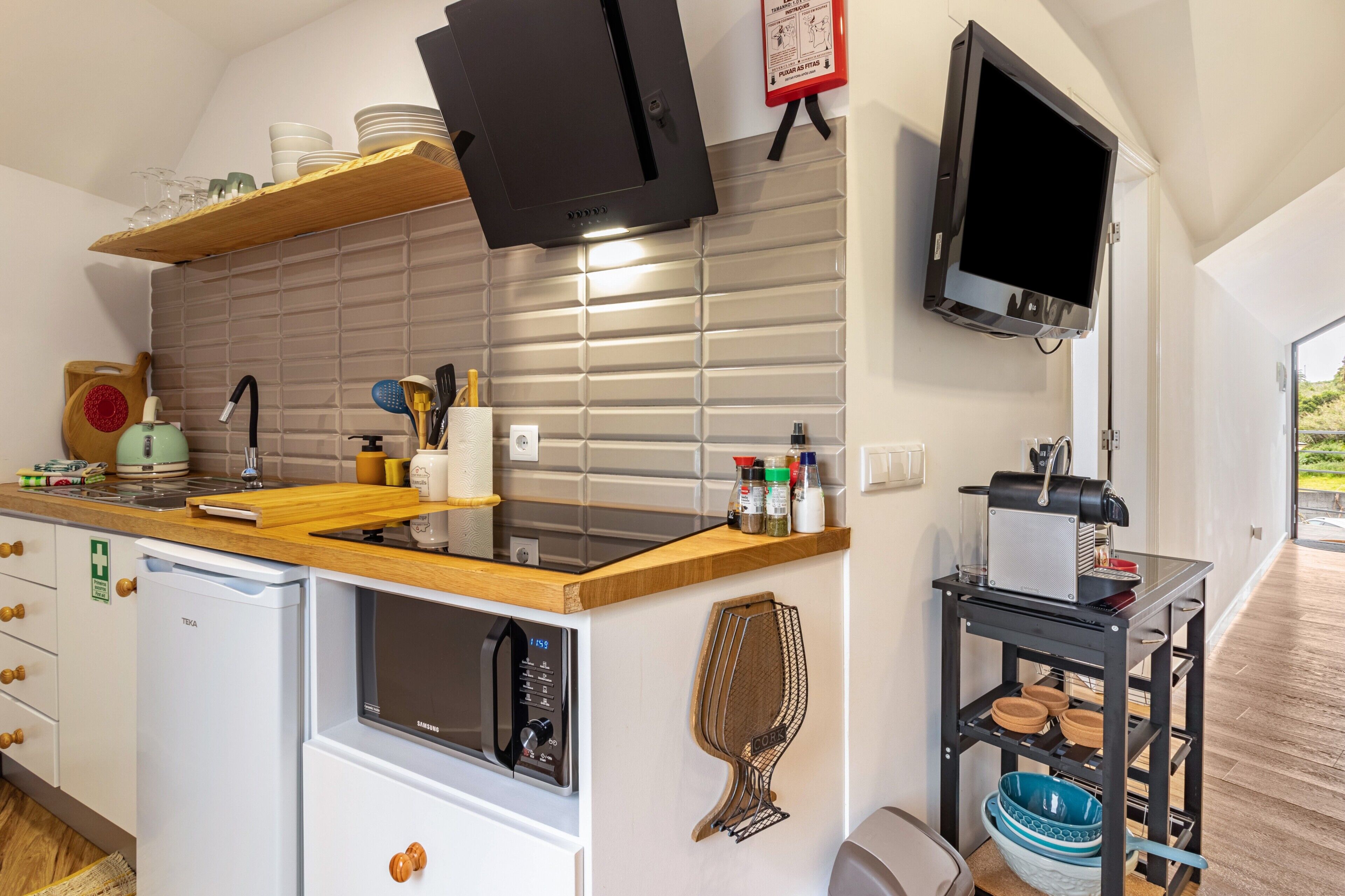 Una cocina compacta equipada con microondas, tostadora y un refrigerador pequeño.