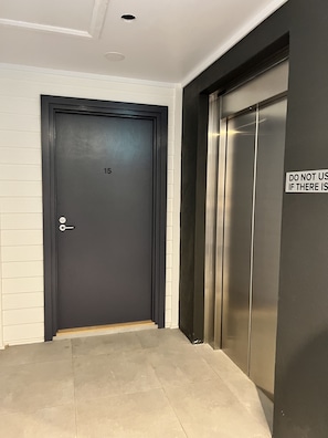 Elevator and door to room 15, part of a numbered entry system.