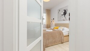Un dormitorio con cama, lámpara de noche y un cuadro en la pared.