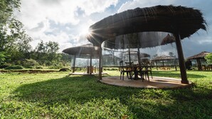A gazebo with a thatched roof, surrounded by lush greenery and a clear sky. - Shatavari Eco Resort (Khanapur)