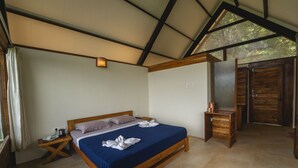 A bedroom with a wooden bed, a nightstand, a small table, and a wooden wardrobe. - Shatavari Eco Resort (Khanapur)