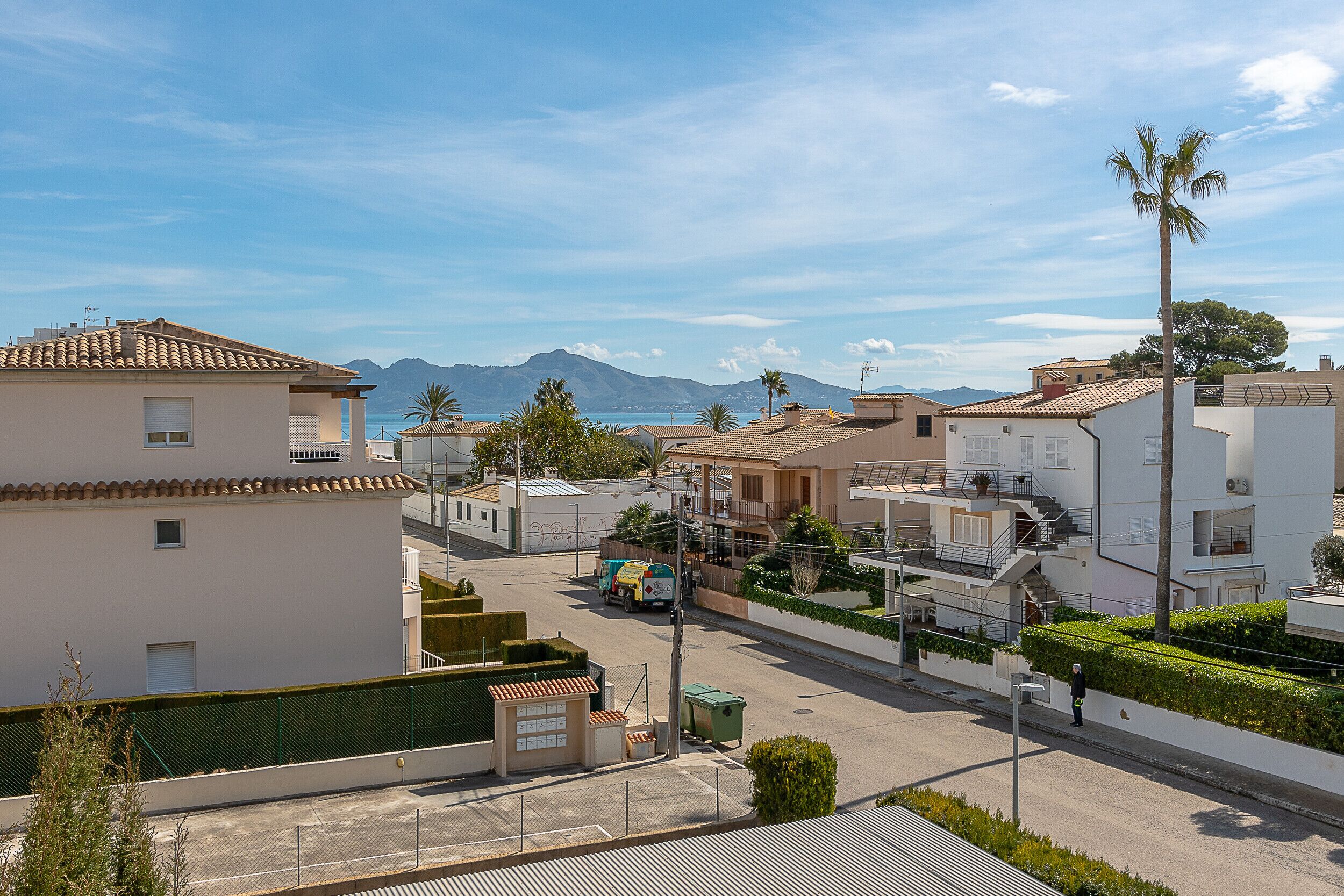 A residential area with a clear view of the sea and mountains in the background.