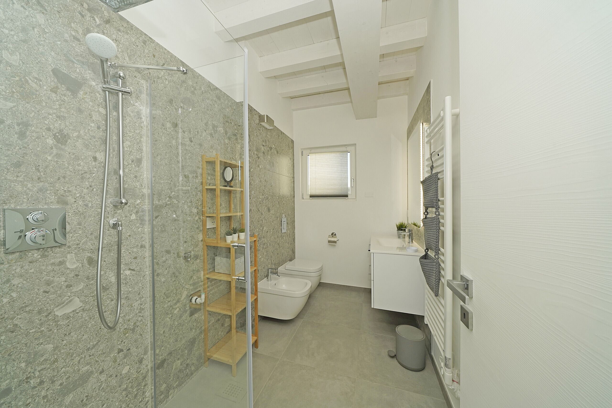 A modern bathroom with a shower, toilet, and vanity.