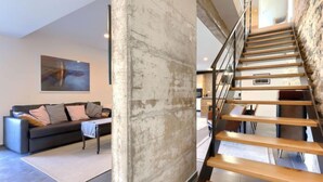 Un salon moderne avec un canapé, une table basse et un tableau au mur.